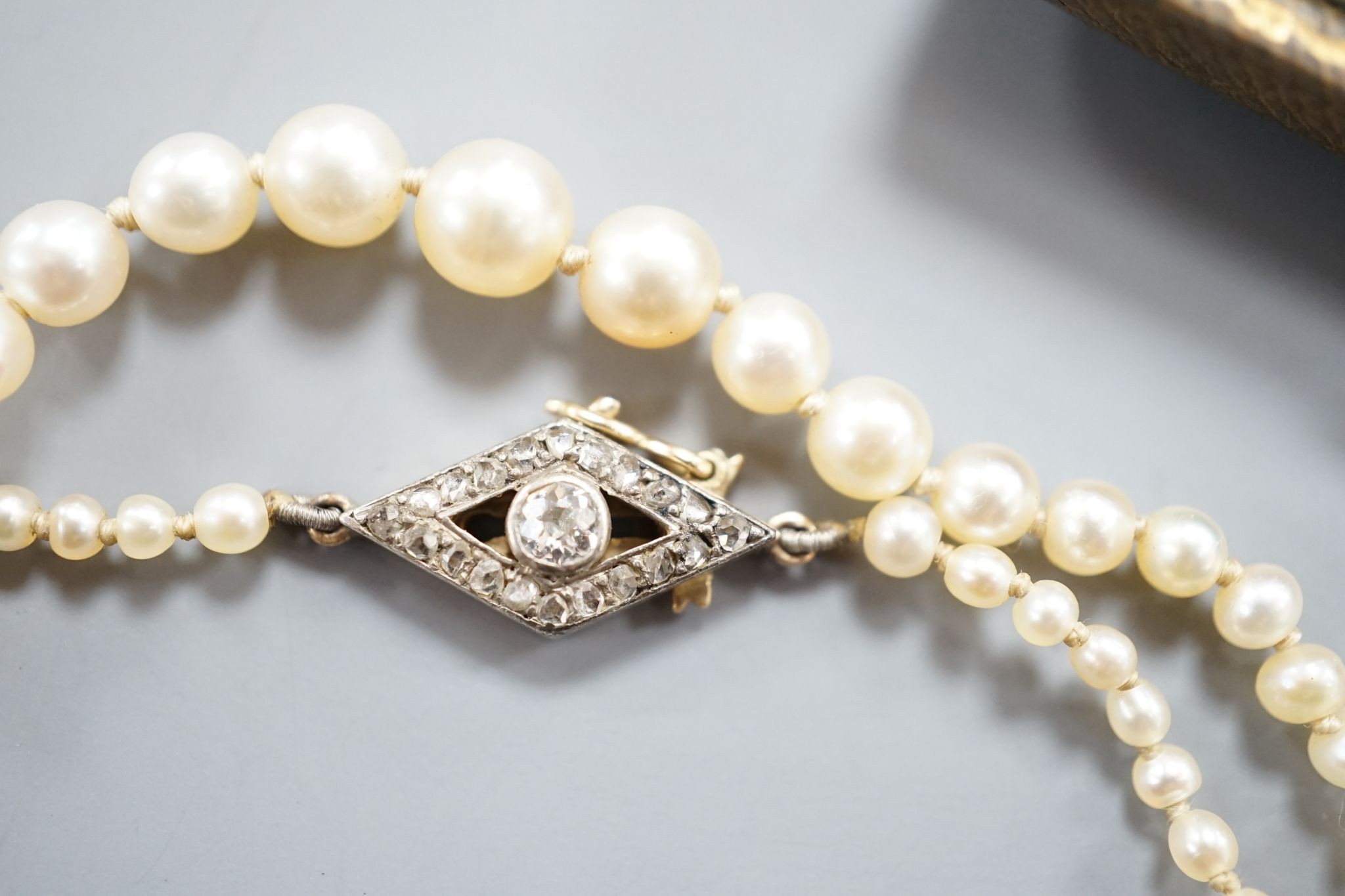 A single strand graduated seed pearl necklace, with yellow metal and diamond set clasp 42cm and a cased pair of similar Austro Hungarian ear clips.